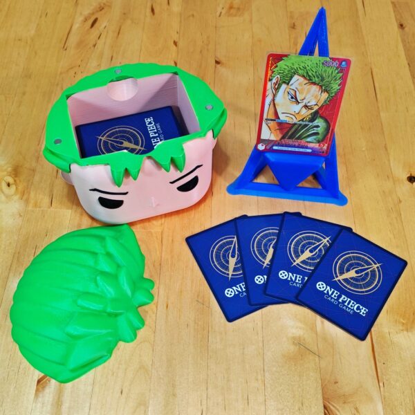 Deckbox Funko Pop Zoro abierta con cartas de One Piece TCG y soporte de exhibición.