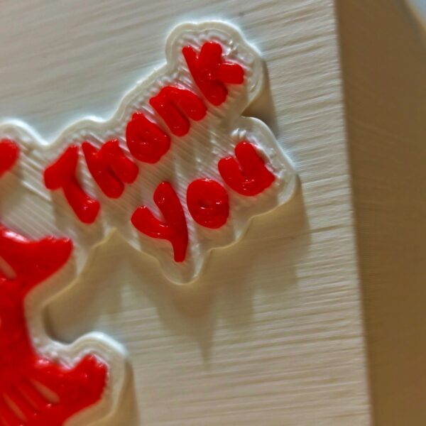 Detalle lateral de la deckbox con el texto "Thank You" en relieve rojo