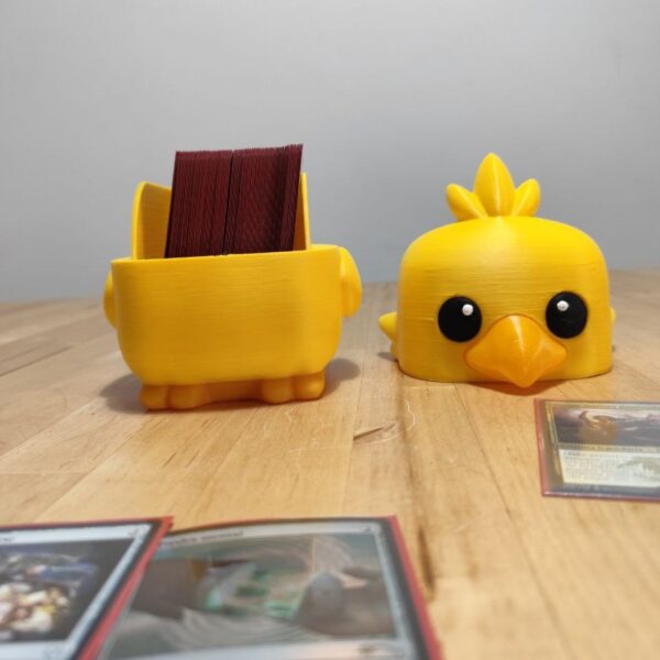 Caja deckbox inspirada en Chocobo Baby para cartas TCG, mostrando el interior con cartas enfundadas.