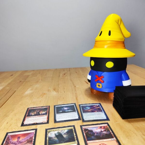 Deckbox inspirada en Vivi Ornitier de Final Fantasy con cartas TCG alrededor sobre una mesa de madera.