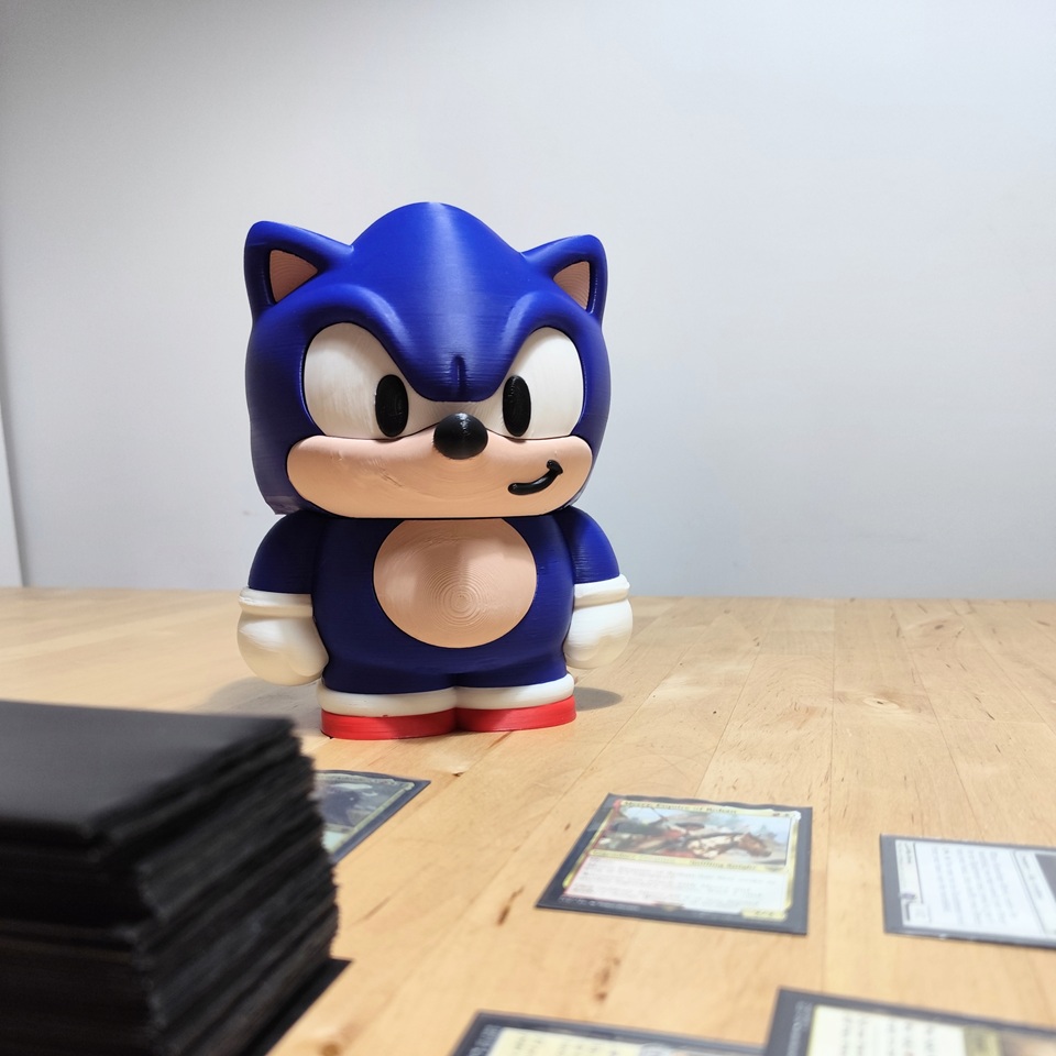 Deckbox 3D de Sonic the Hedgehog junto a cartas coleccionables, ideal para almacenar y proteger tu mazo.